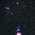 冬の夜空に輝くオリオンの三ツ星と大星雲