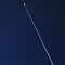 夜のアラスカに飛翔していく夜間フライトと人工衛星
