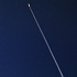 夜のアラスカに飛翔していく夜間フライトと人工衛星